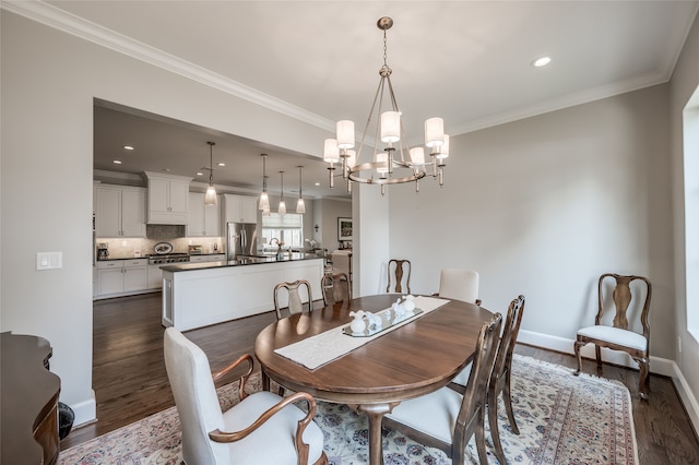 dining area with dark hardwood / wood-style flooring, an inviting chandelier, and ornamental molding