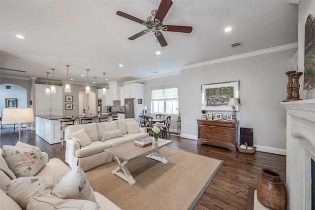 living room featuring ornamental molding, ceiling fan, and dark wood-type flooring