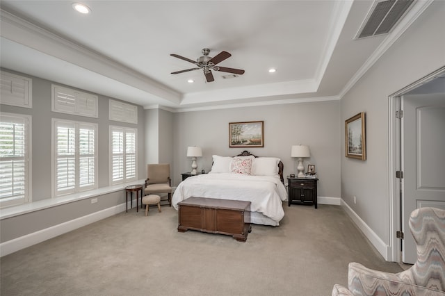 carpeted bedroom with a tray ceiling, ceiling fan, and crown molding