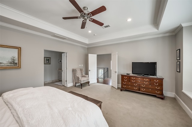 carpeted bedroom featuring ensuite bath, a raised ceiling, ceiling fan, and crown molding