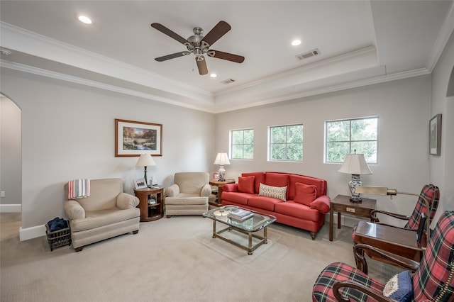 living room featuring a tray ceiling, crown molding, carpet flooring, and ceiling fan