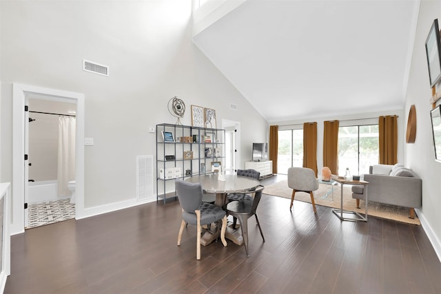 dining area featuring dark hardwood / wood-style flooring and high vaulted ceiling