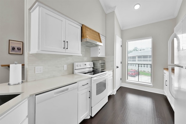 kitchen with wall chimney range hood, white cabinetry, dark hardwood / wood-style floors, and white appliances