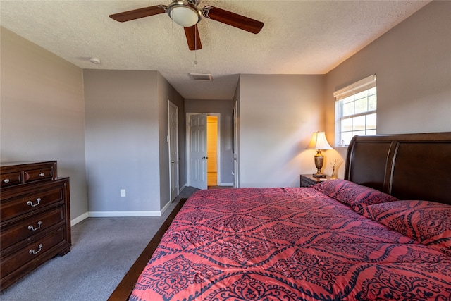 bedroom featuring a textured ceiling, dark carpet, and ceiling fan