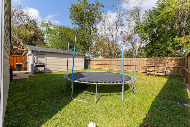 view of yard with an outdoor structure and a trampoline