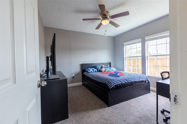 carpeted bedroom with ceiling fan and a textured ceiling