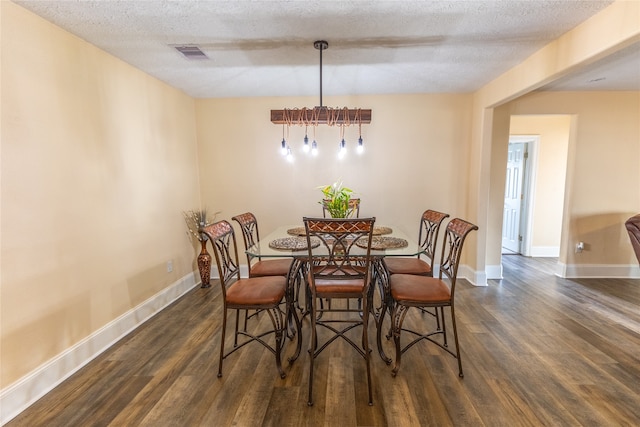 dining room featuring a textured ceiling and dark wood-type flooring