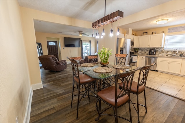 dining area with hardwood / wood-style flooring, ceiling fan, and sink