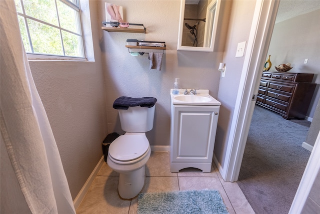 bathroom with walk in shower, tile patterned flooring, vanity, and toilet