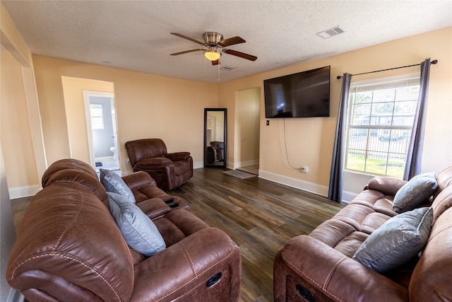 living room with a textured ceiling, ceiling fan, and dark hardwood / wood-style floors