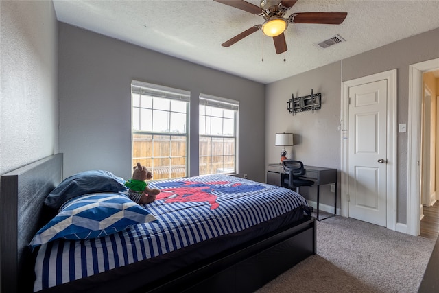 bedroom featuring carpet flooring, ceiling fan, and a textured ceiling