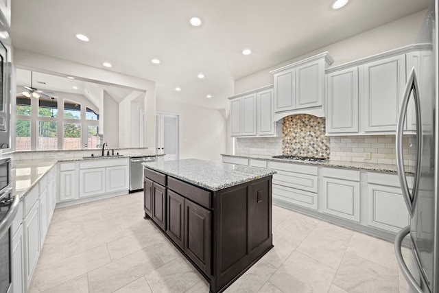 kitchen featuring tasteful backsplash, stainless steel appliances, ceiling fan, sink, and white cabinetry