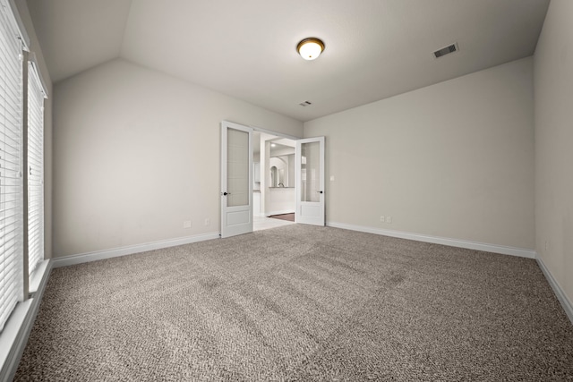 unfurnished room featuring lofted ceiling, carpet floors, and french doors