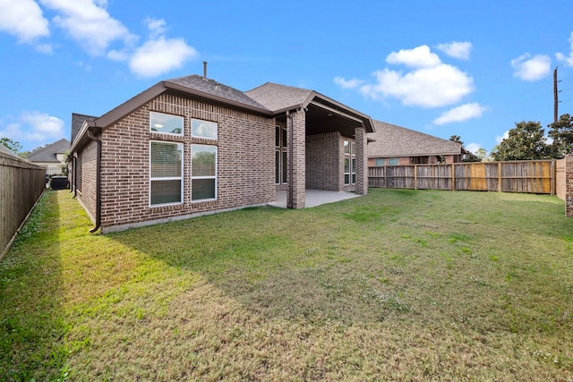 rear view of property featuring a yard and a patio