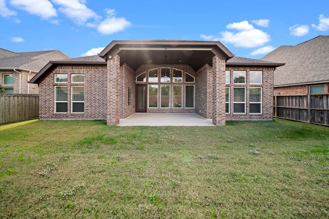 back of house featuring a lawn and a patio