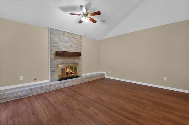 unfurnished living room with hardwood / wood-style floors, vaulted ceiling, ceiling fan, and a brick fireplace