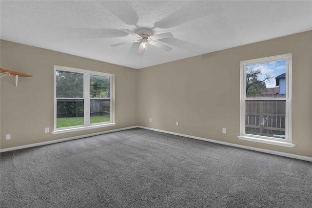 carpeted spare room featuring ceiling fan and a textured ceiling