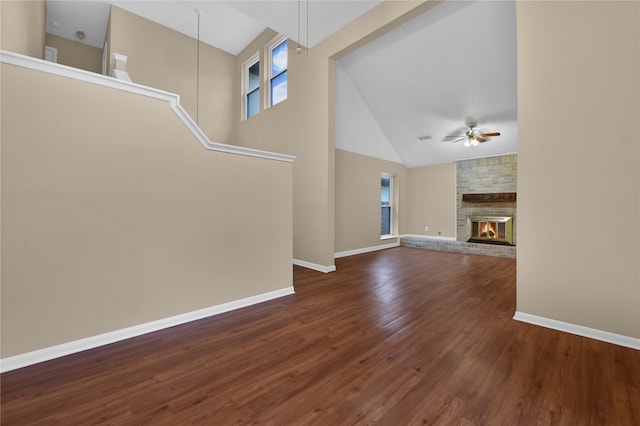 unfurnished living room featuring ceiling fan, a large fireplace, high vaulted ceiling, and dark wood-type flooring