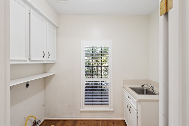 laundry area featuring hookup for an electric dryer, cabinets, dark wood-type flooring, and sink