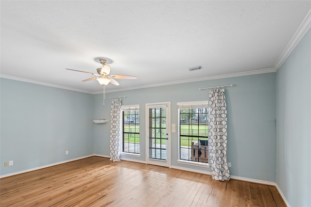 spare room featuring a textured ceiling, light hardwood / wood-style floors, ceiling fan, and ornamental molding