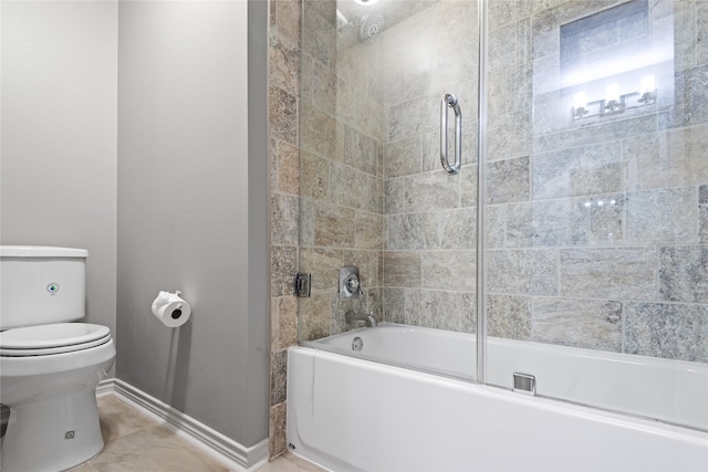 bathroom featuring toilet and bath / shower combo with glass door