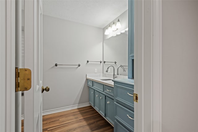 bathroom with vanity, wood-type flooring, and a textured ceiling