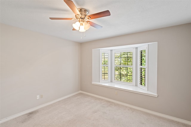 spare room featuring light carpet and ceiling fan