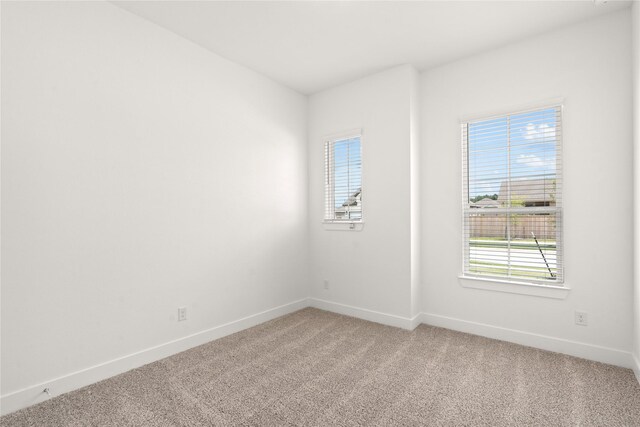 empty room with a healthy amount of sunlight and carpet floors