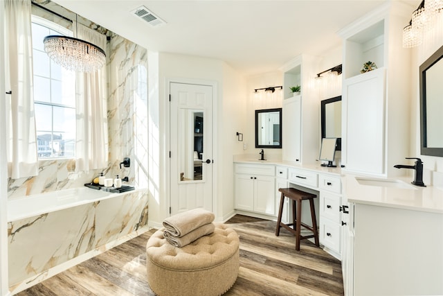 bathroom featuring a washtub, vanity, a chandelier, and hardwood / wood-style flooring