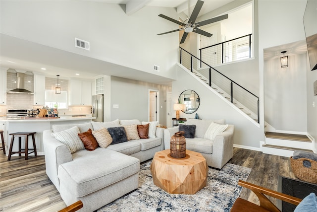 living room featuring beam ceiling, light hardwood / wood-style flooring, and plenty of natural light