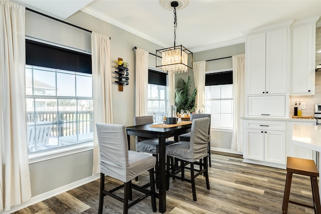 dining space with crown molding, light hardwood / wood-style floors, and an inviting chandelier