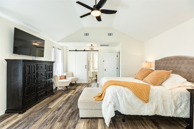 bedroom with lofted ceiling, ensuite bathroom, ceiling fan, a barn door, and wood-type flooring