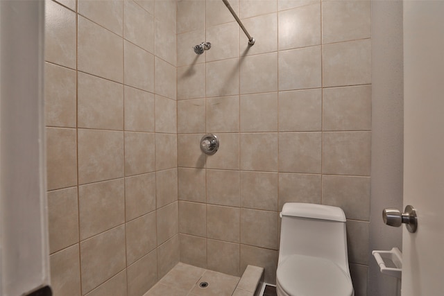 bathroom featuring tiled shower and toilet