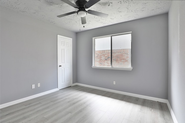 spare room featuring ceiling fan, a textured ceiling, and light wood-type flooring