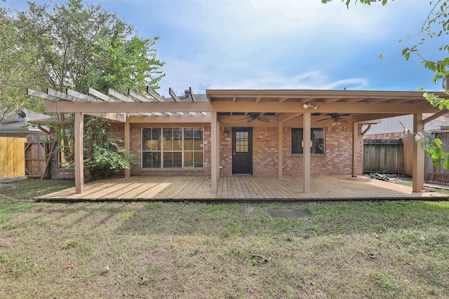 rear view of property with a yard, a pergola, ceiling fan, and a wooden deck