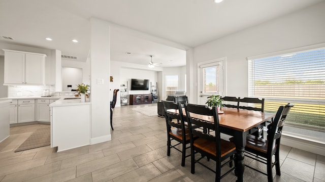 dining space featuring ceiling fan and sink