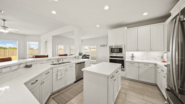 kitchen featuring white cabinetry, a wealth of natural light, sink, and stainless steel appliances