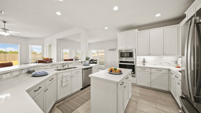 kitchen featuring plenty of natural light, sink, white cabinetry, and stainless steel appliances