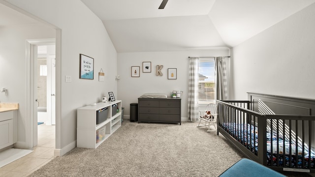 carpeted bedroom featuring a crib and vaulted ceiling