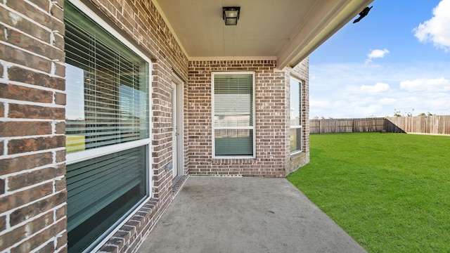 doorway to property featuring a lawn and a patio