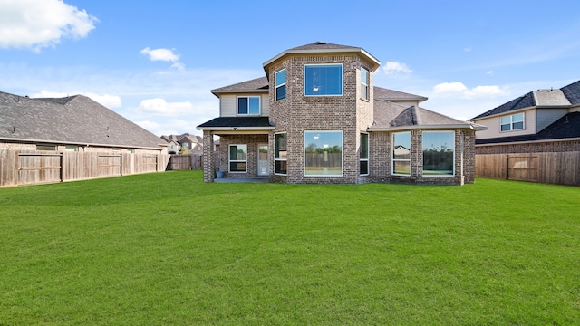 back of property with a patio area and a yard