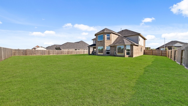 rear view of house featuring a yard