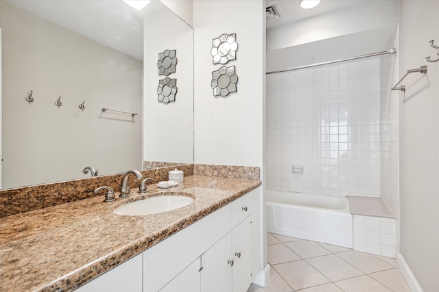 bathroom with tile patterned floors, tiled shower / bath combo, and vanity