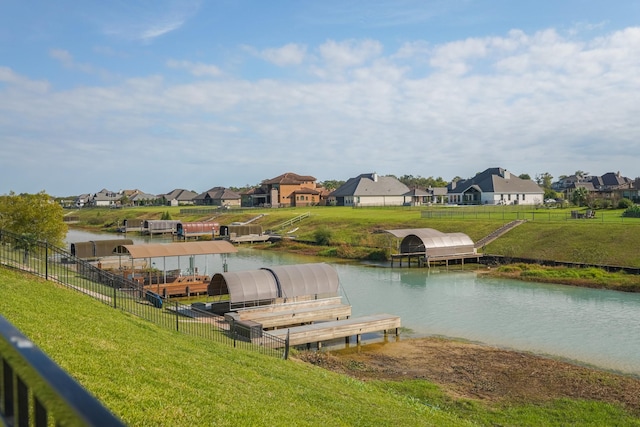 view of dock with a water view and a lawn