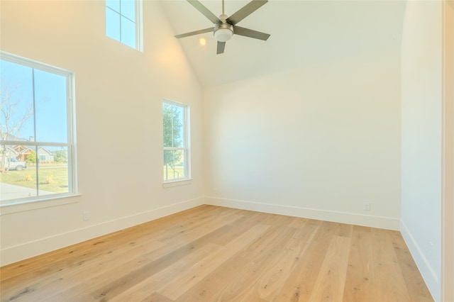 empty room with high vaulted ceiling, light hardwood / wood-style flooring, and ceiling fan