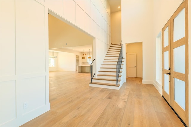 interior space featuring light wood-type flooring and a high ceiling