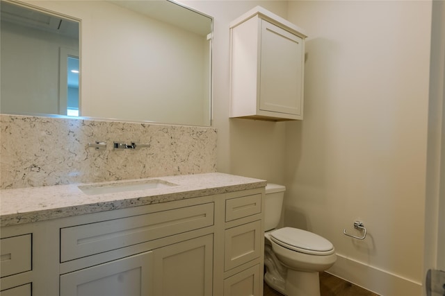 bathroom with tasteful backsplash, vanity, and toilet