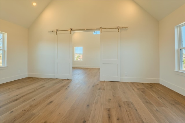 empty room with vaulted ceiling and light hardwood / wood-style floors