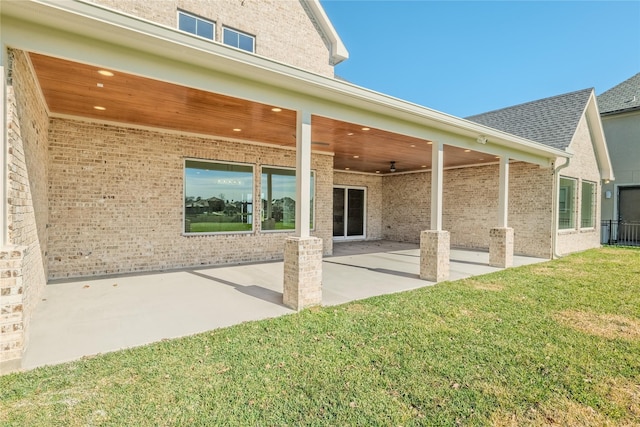 rear view of property featuring a yard and a patio