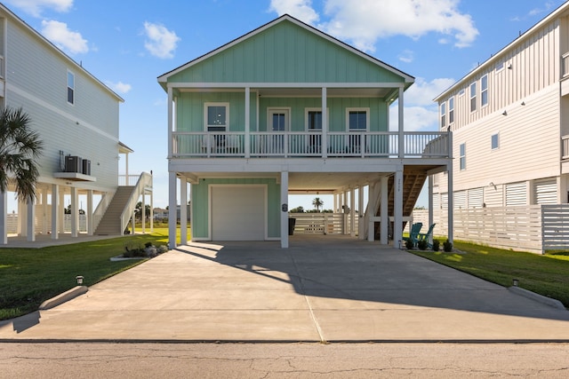 coastal inspired home featuring a garage, a front lawn, a carport, and a porch